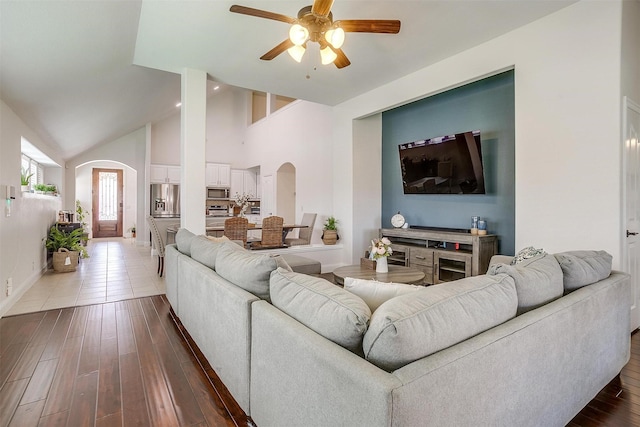 living room featuring ceiling fan, high vaulted ceiling, and hardwood / wood-style flooring