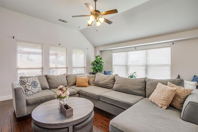 living room featuring a wealth of natural light, ceiling fan, dark wood-type flooring, and vaulted ceiling