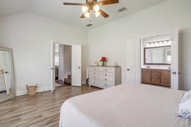 bedroom with hardwood / wood-style floors, ceiling fan, lofted ceiling, and ensuite bathroom