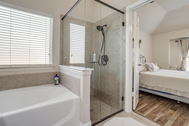 bathroom featuring hardwood / wood-style floors, plus walk in shower, and vaulted ceiling