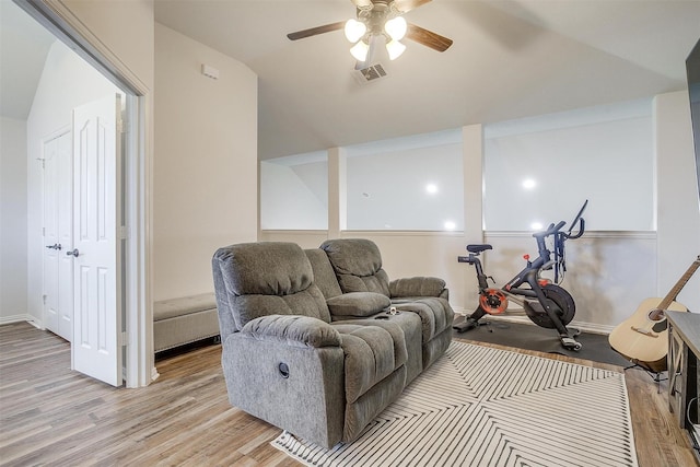 exercise room with light hardwood / wood-style floors, ceiling fan, and lofted ceiling