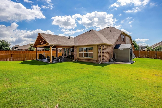 back of house with a lawn, a patio area, and a storage shed