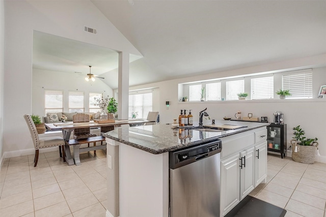 kitchen with dishwasher, sink, vaulted ceiling, light tile patterned flooring, and white cabinetry