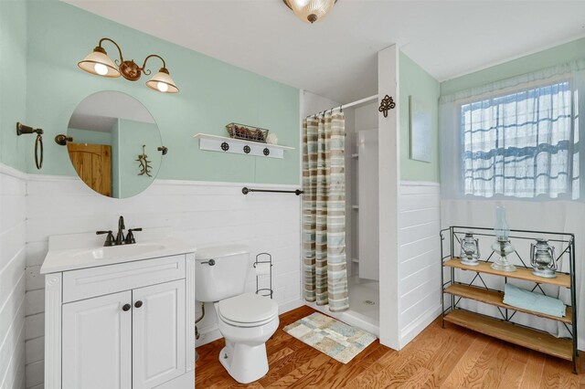 bathroom featuring curtained shower, toilet, vanity, and hardwood / wood-style flooring