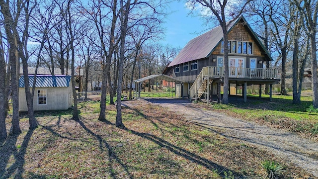 view of side of home with an outbuilding, a deck, and a carport