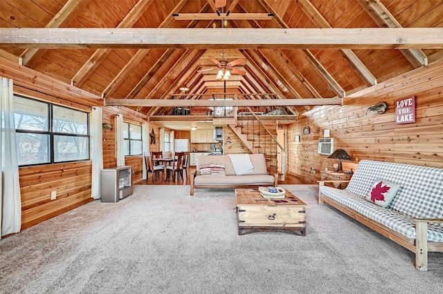 unfurnished living room featuring wood ceiling, vaulted ceiling with beams, carpet, heating unit, and wood walls