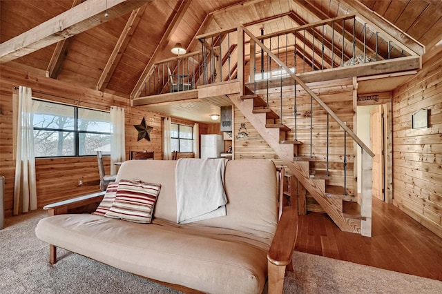 carpeted living room featuring wood walls, beamed ceiling, wooden ceiling, and high vaulted ceiling