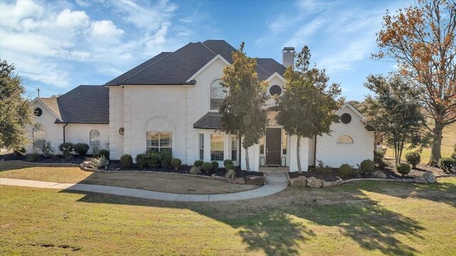 french country inspired facade featuring a front yard