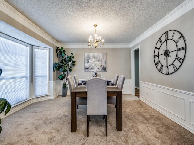 dining room featuring ornamental molding, light colored carpet, a textured ceiling, and a chandelier