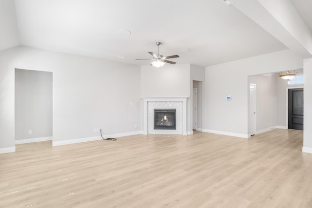 unfurnished living room with ceiling fan, a fireplace, and light hardwood / wood-style floors