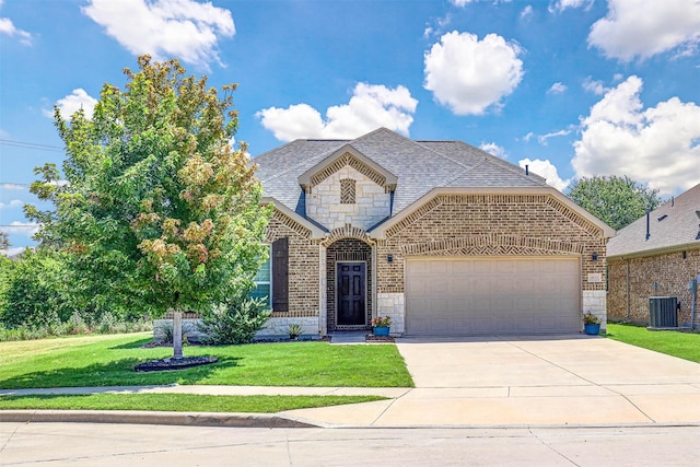 view of front of home featuring a garage, a front lawn, and central air condition unit