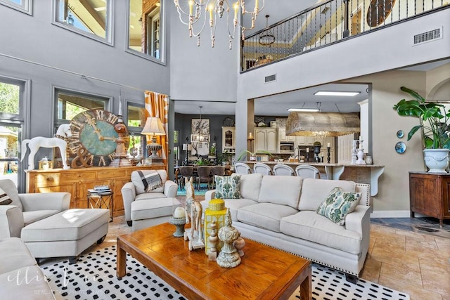 living room with a notable chandelier and a towering ceiling