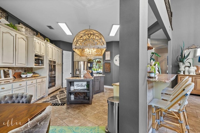 kitchen with hanging light fixtures, stainless steel appliances, light stone counters, a notable chandelier, and decorative backsplash