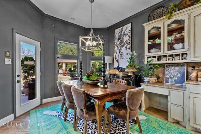 dining room with crown molding, light tile patterned floors, and an inviting chandelier