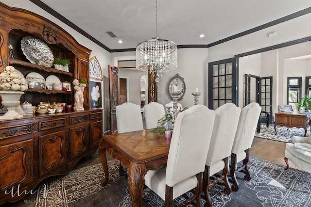 dining room featuring a chandelier, french doors, dark hardwood / wood-style flooring, and crown molding