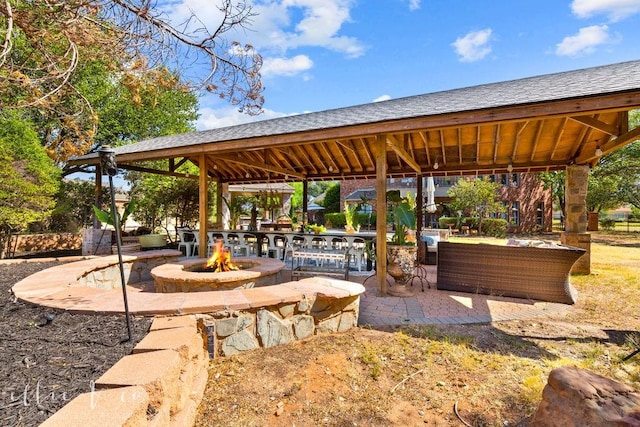 view of home's community with a gazebo, an outdoor fire pit, and a patio area