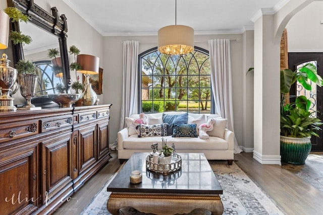 living area featuring a chandelier, hardwood / wood-style flooring, and ornamental molding