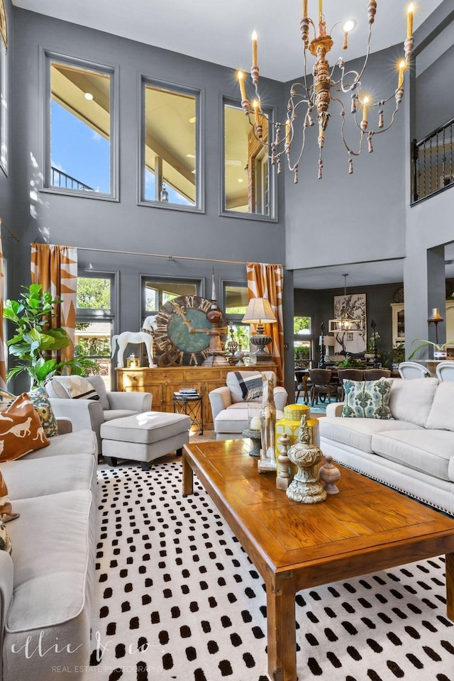 living room featuring a high ceiling, an inviting chandelier, and a wealth of natural light