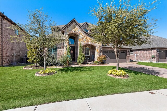 view of front of house with central AC unit, a garage, and a front yard