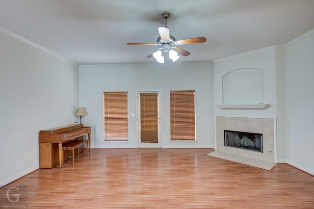 unfurnished living room with a tile fireplace, light wood-type flooring, ceiling fan, and crown molding