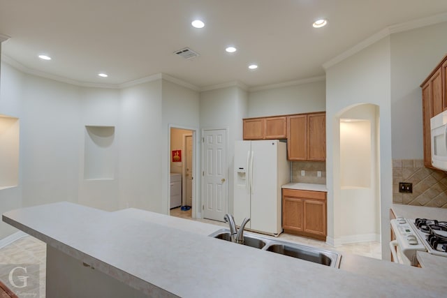 kitchen with white appliances, sink, decorative backsplash, ornamental molding, and washer / clothes dryer