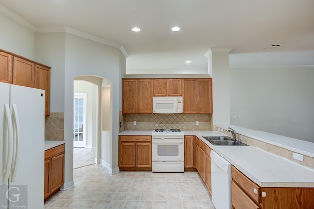 kitchen with ornamental molding, white appliances, sink, and tasteful backsplash