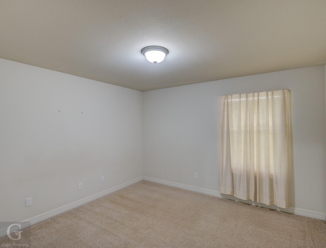 unfurnished room featuring light carpet