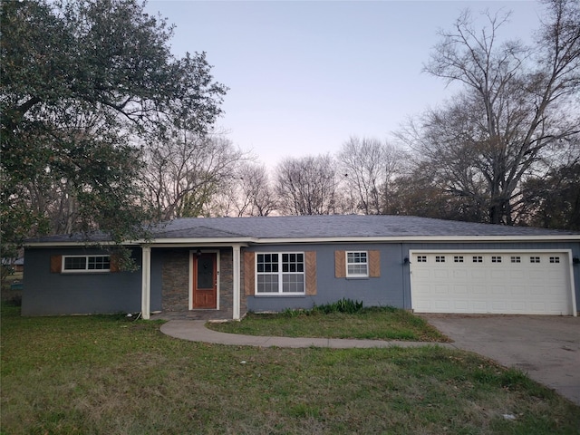 ranch-style house featuring a yard and a garage