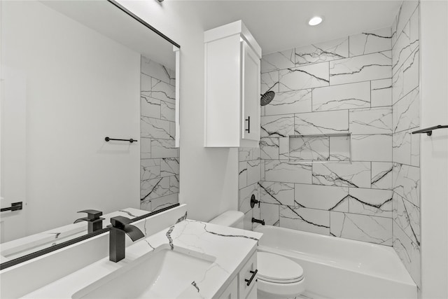 full bathroom featuring tiled shower / bath, vanity, and toilet