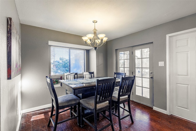 dining area featuring dark hardwood / wood-style floors and a chandelier