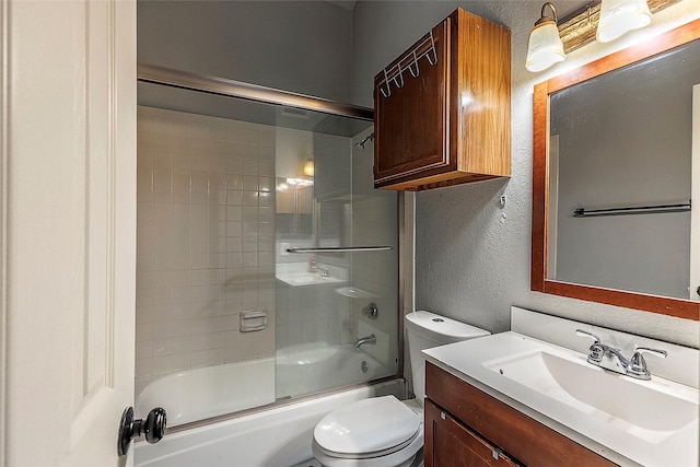 full bathroom featuring toilet, vanity, and bath / shower combo with glass door