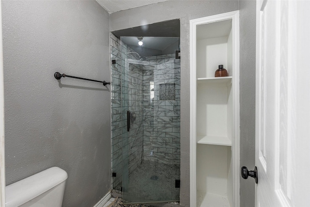 bathroom with a shower with door and toilet