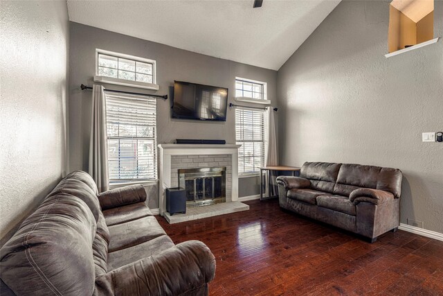 living room featuring dark hardwood / wood-style floors, vaulted ceiling, and a brick fireplace