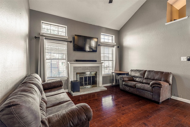 living room with dark hardwood / wood-style flooring, high vaulted ceiling, and a fireplace