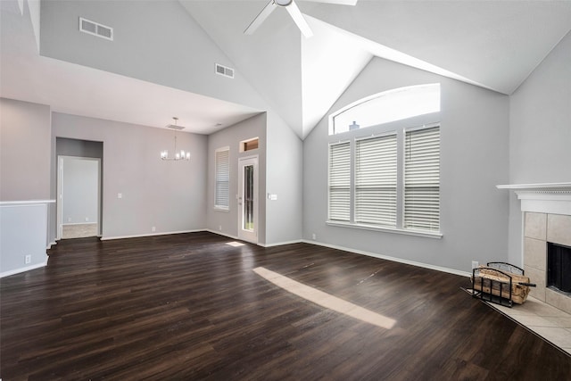 unfurnished living room featuring a tile fireplace, hardwood / wood-style floors, ceiling fan with notable chandelier, and vaulted ceiling