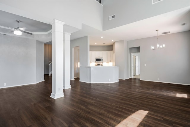 unfurnished living room featuring dark hardwood / wood-style flooring, a high ceiling, and ceiling fan with notable chandelier