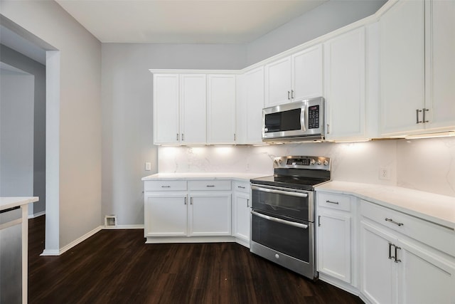 kitchen with white cabinets, appliances with stainless steel finishes, and dark hardwood / wood-style floors