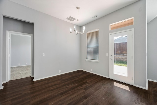 unfurnished dining area with dark hardwood / wood-style floors and an inviting chandelier