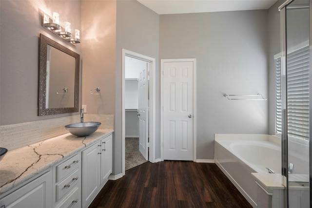 bathroom featuring hardwood / wood-style floors, vanity, and a bath