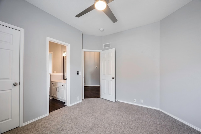 unfurnished bedroom with connected bathroom, ceiling fan, and dark carpet