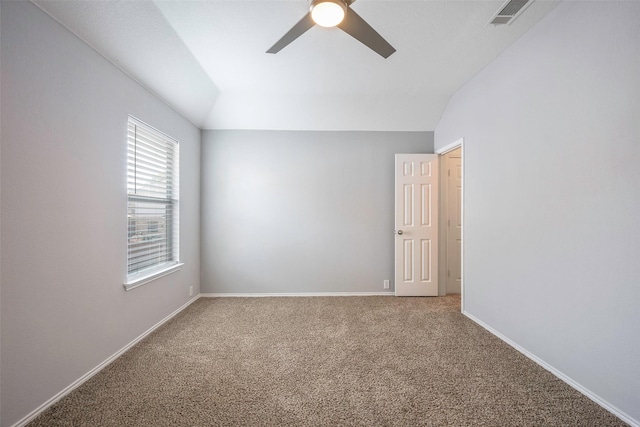 spare room featuring carpet floors, vaulted ceiling, and ceiling fan