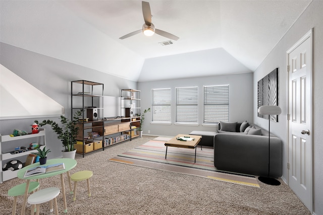 carpeted living room with ceiling fan and vaulted ceiling