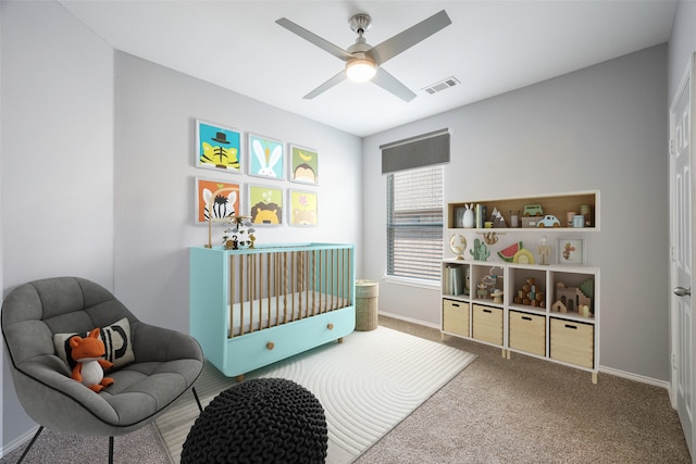 carpeted bedroom featuring a crib and ceiling fan