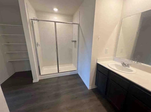 bathroom featuring hardwood / wood-style floors, vanity, and walk in shower