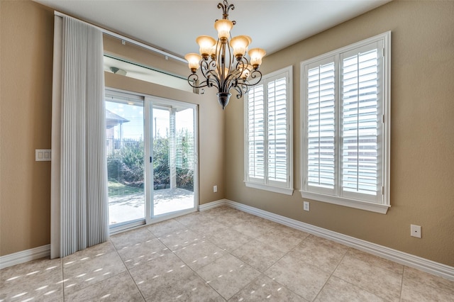 spare room featuring a notable chandelier and light tile patterned flooring