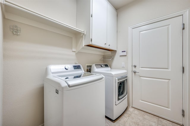 washroom with cabinets, light tile patterned floors, and separate washer and dryer