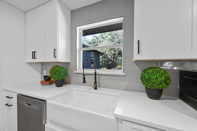 kitchen featuring tasteful backsplash, dishwasher, white cabinets, and sink