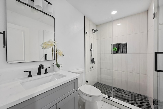 bathroom featuring tile patterned flooring, vanity, toilet, and walk in shower