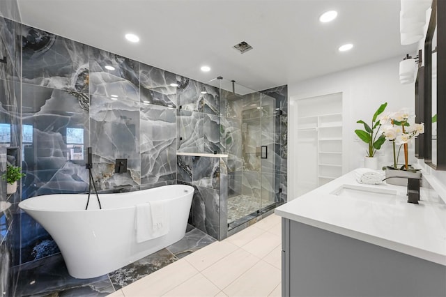 bathroom with vanity, separate shower and tub, and tile walls