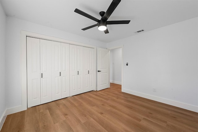 unfurnished bedroom featuring ceiling fan, light hardwood / wood-style floors, and a closet